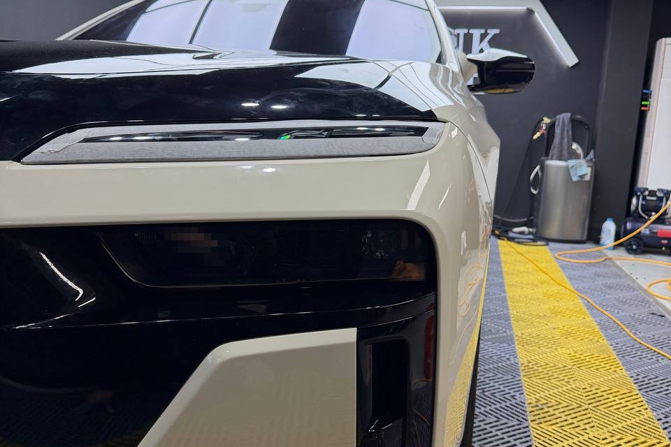 블랭크랩 작업장에서 아이보리 · 블랙 투톤으로 랩핑 중인 BMW i7 M70 전면